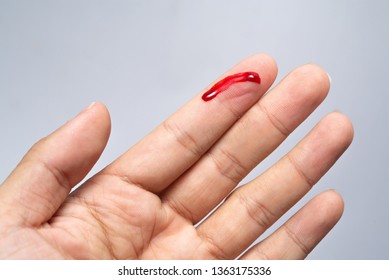 Bleeding blood from the cut finger wound. Injured finger with bleeding open cut wound. Closeup of finger human hand is cut hurt bleeding with bright red blood. 