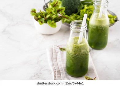 Blended green smoothie with ingredients on the white table. - Powered by Shutterstock