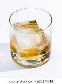 Blended Scotch Whiskey Served In A Short Glass With A Large Ice Cube Isolated On A White Background