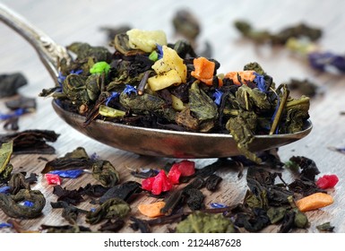 blended tea. green tea leaves with flower petals and dried fruits in a spoon. close up - Shutterstock ID 2124487628