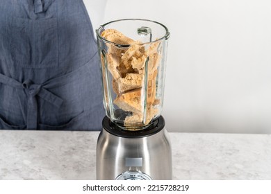 Blending stale bread in a blender to make bread crumbs. - Shutterstock ID 2215728219