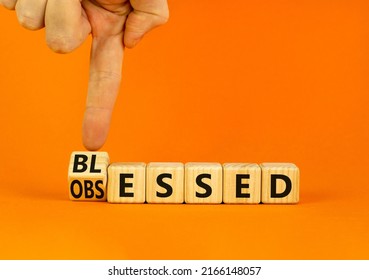 Blessed or obsessed symbol. Businessman turns wooden cubes and changes the concept word Obsessed to Blessed. Beautiful orange table orange background. Business blessed or obsessed concept. Copy space.