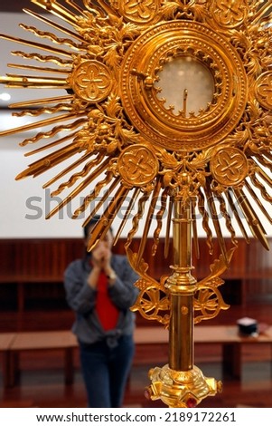 The Blessed Sacrament in a monstrance. Eucharist adoration.  Woman praying.  Thi Nghe Church.  Ho Chi Minh City. Vietnam. 