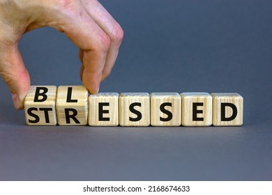 Blessed or stressed symbol. Businessman turns wooden cubes and changes the concept word Stressed to Blessed. Beautiful grey table grey background. Business blessed or stressed concept. Copy space.