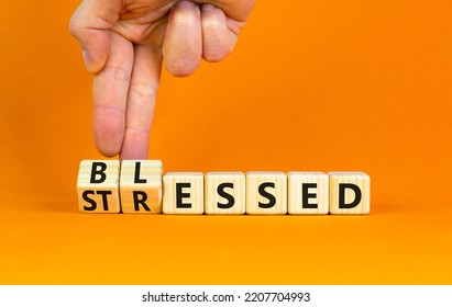 Blessed or stressed symbol. Businessman turns wooden cubes and changes the concept word Stressed to Blessed. Beautiful orange table orange background. Business blessed or stressed concept. Copy space.