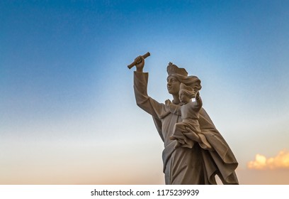The Blessed Virgin Mary holding Baby Jesus spreading arms on blu sky background