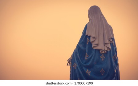 The blessed Virgin Mary statue figure in a warm tone - sunset scene. Catholic praying for our lady - The Virgin Mary.
