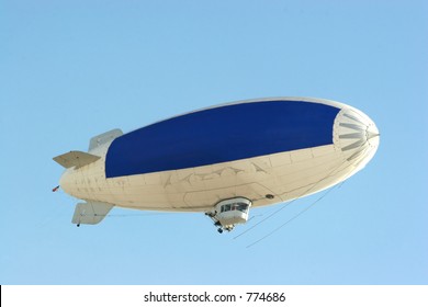 Blimp Flying In Clear Blue Sky With Blue Copy Space To Advertise Your Message