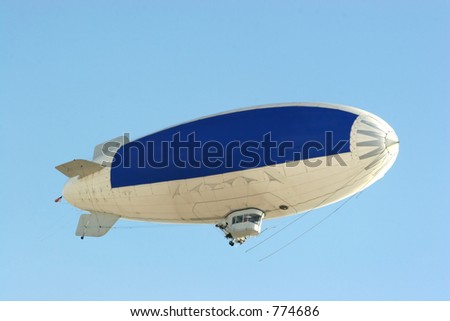 blimp flying in clear blue sky with blue copy space to advertise your message