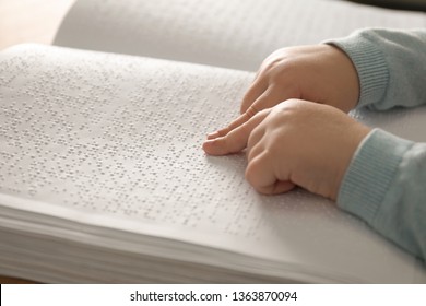 Blind child reading book written in Braille, closeup - Powered by Shutterstock