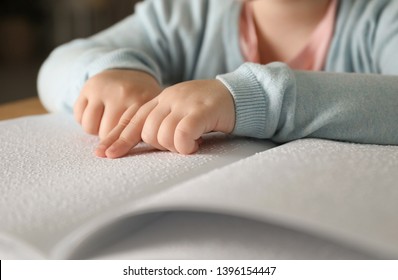 Blind child reading book written in Braille, closeup - Powered by Shutterstock