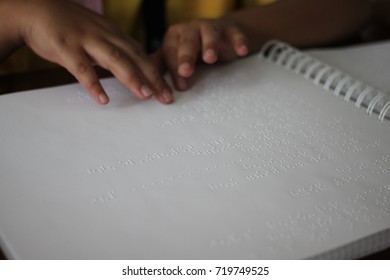 A Blind Child Reading Braille Text Book.