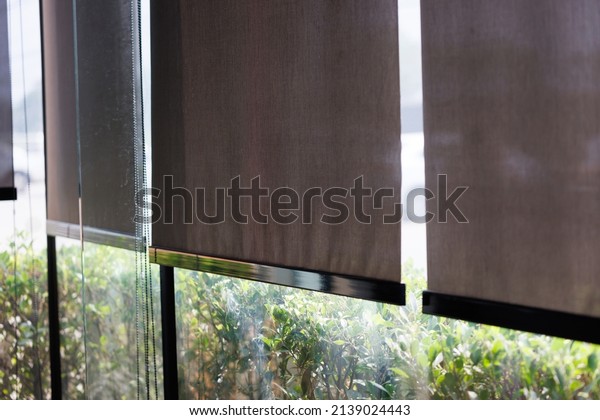 blind curtain or black blinds\
Roller sun protection in office with garden and car  park\
background.