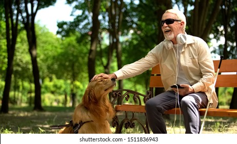 Blind man with earphones stroking dog, full life of impaired, enjoying time - Shutterstock ID 1511836943