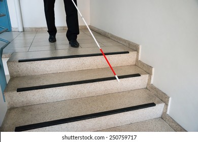 Blind Man Moving Down On Stairway Holding Stick