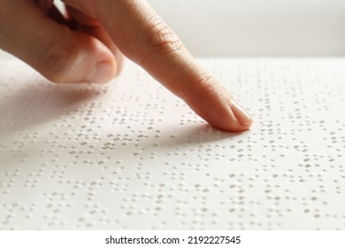 A blind man reads a Braille book with his hands - Powered by Shutterstock