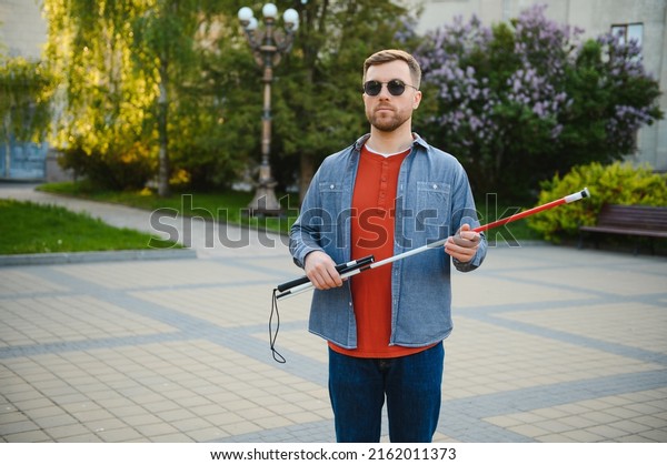 Blind man.\
Visually impaired man with walking\
stick