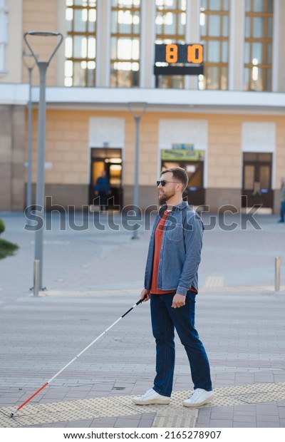 Blind man.\
Visually impaired man with walking\
stick