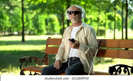 Blind Old Man Wearing Earphones Listening Audiobook, Voice Message In Cellphone