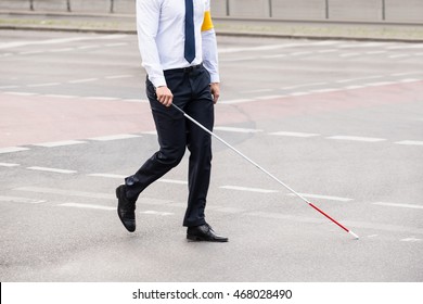 Blind Person With White Stick Walking On Street