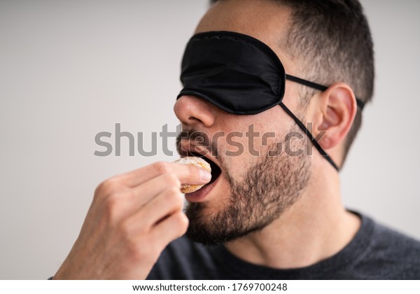 Blind Taste.\
Blindfolded Food Test. Man\
Face