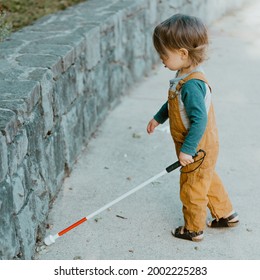 Blind Or Visually Impaired Child (Kid, Toddle, Boy) Exploring Concrete Wall With White Cane; Independent Exploration