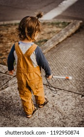 Blind Or Visually Impaired Child/Kid/Toddler/Preschooler/Boy Walking Through Neighborhood With Long White Cane; At Sidewalk Corner; Back To Camera