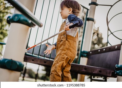 Blind Or Visually Impaired Toddler/Child/Boy/Kid/Student/Preschooler Playing On Playground Equipment; Independently Climbing Up Stairs And Exploring With Long White Cane