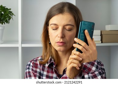 Blind Woman Holding Mobile Phone Using Speakerphone.