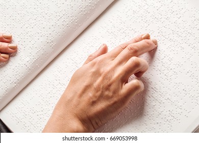 Blind woman read book written in Braille. Close up finger touch to braille Code - Powered by Shutterstock