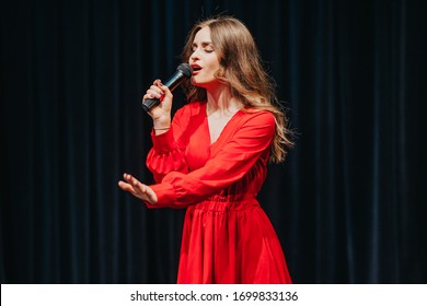 Blind woman sings. Music star performs on stage. Disable girl with microphone in hand. Fashionably dressed lady at opera. Actress doing the show at theatre scene. Attempt of theatrical performance. - Powered by Shutterstock