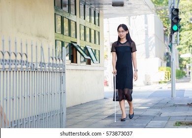 Blind Woman Walking On Sidewalk