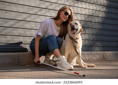 A blind woman walks her guide dog on the street. Girl hugging a labrador.