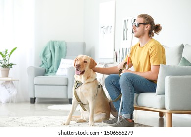 Blind Young Man With Guide Dog At Home