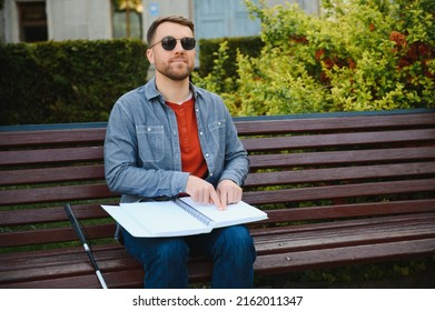 Blinded Man Reading By Touching Braille Book.