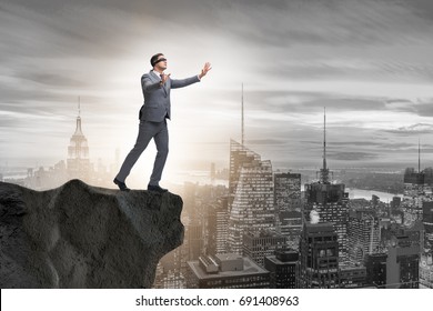 Blindfold businessman standing on tip of cliff - Powered by Shutterstock