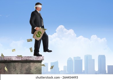 Blindfolded business man with bag of money is about to walk off the edge of a building representing financial risk, management, planning, investments, savings, and many other financial concepts.