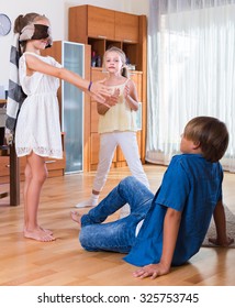 Blindfolded little girl catching kids playing in Kagome at home