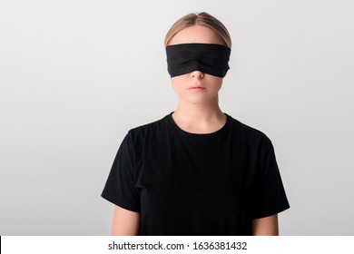 blindfolded young woman in black t-shirt isolated on white, human rights concept