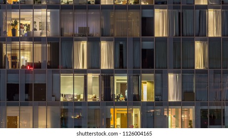 Blinkt und blinkt Fenster des mehrstöckigen Gebäudes aus Glas und Stahl Beleuchtung innen und bewegen Menschen innerhalb von Zeitraffer. Luftbild der modernen Wolkenkratzer in Dubai