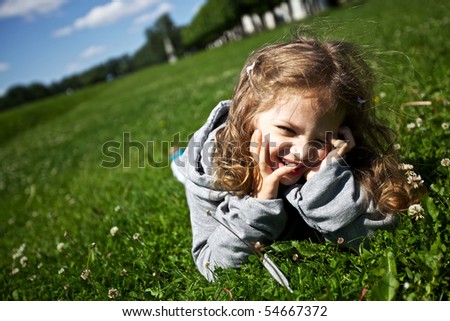 Similar – Littel girl sitting on grass looking curious