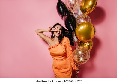 Blissful Slim Woman Dancing At Her Birthday Party. Latin Girl In Orange Dress Enjoying Event.