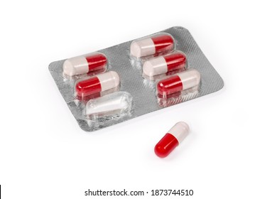 Blister Pack With A Pharmaceutical Product In The Form Of Red-white Pills, One Is The Same Pill Separately On A White Background, Close-up In Selective Focus 
