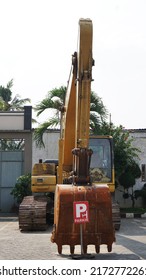 Blitar, Indonesia, 7 Juni 2022: Yellow Ekskavator Or Backhoe Parked On Paved Yard