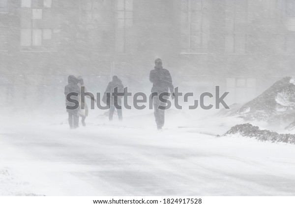 Blizzard bad weather snow and strong wind in the\
city selective focus