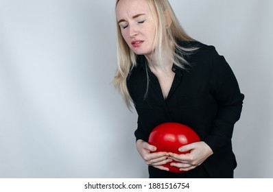 Bloating And Flatulence Concept. The Woman Holds A Red Balloon Near The Abdomen, Which Symbolizes Bloating. Intestinal Tract And Digestive System. Problems With Flatulence Adn Gastrointestinal Tract
