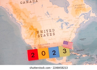 A block with 2023 written on it and a map and flag of United States.