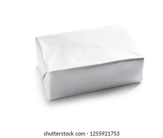 Block of butter in paper wrapper on white background