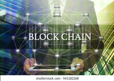 Block chain Text and Distributed computer network with Businessman holding the tablet over the Modern business building glass of skyscrapers, Distributed ledger technology and block chain concept