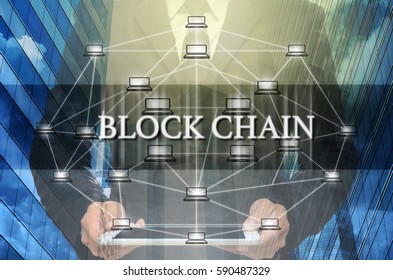 Block chain Text and Distributed computer network with Businessman holding the tablet over the Modern business building glass of skyscrapers, Distributed ledger technology and block chain concept